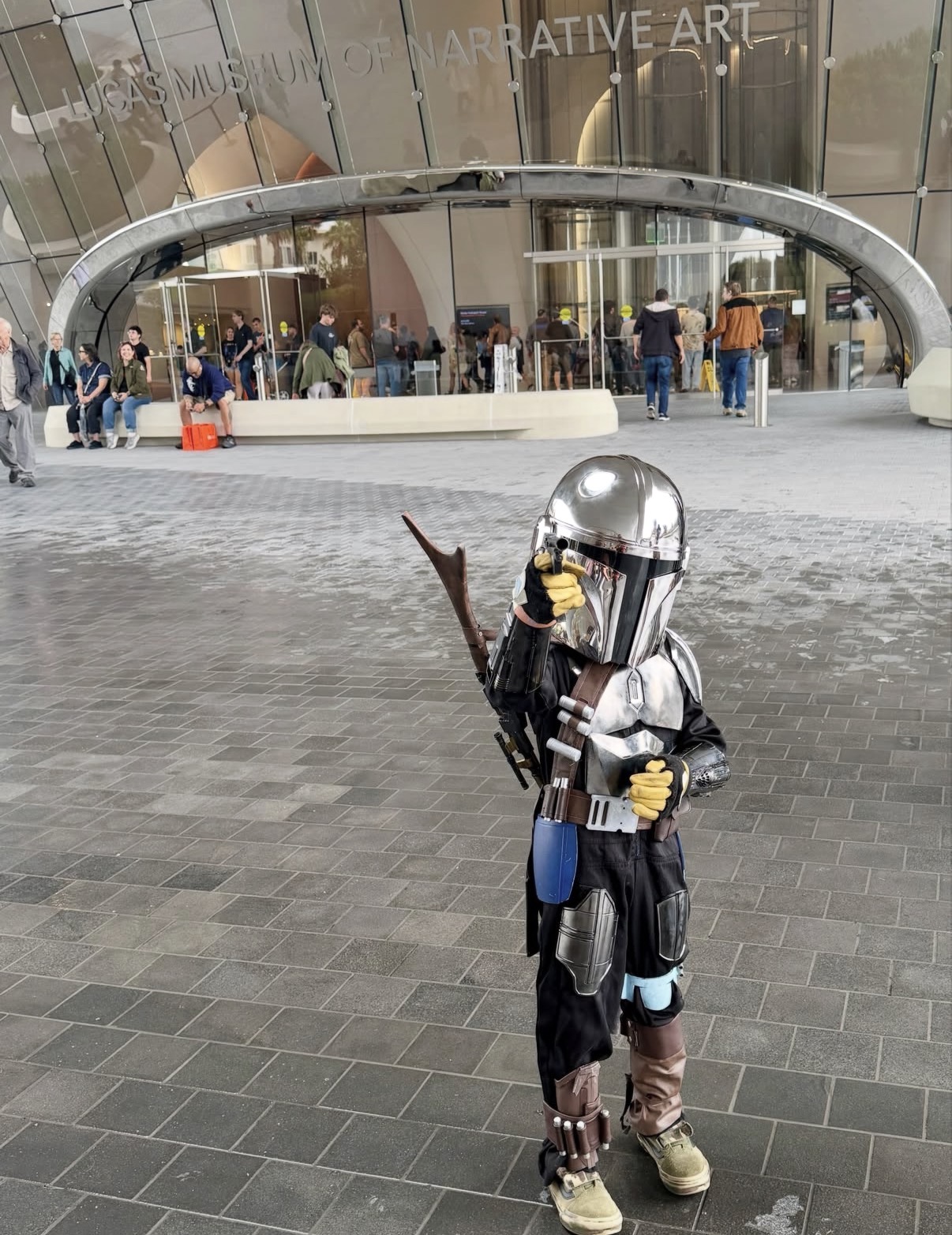 A young Star Wars fan in costume outside the Lucas Museum entrance