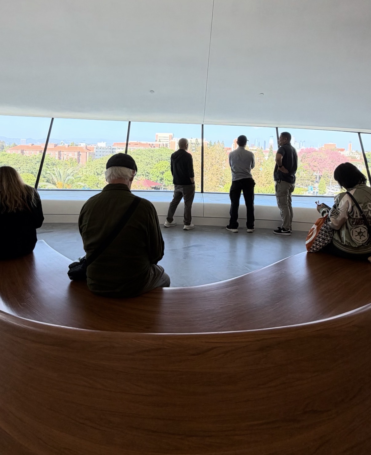 Curved bench seating beside the museum's large windows, with a view across Exposition Park